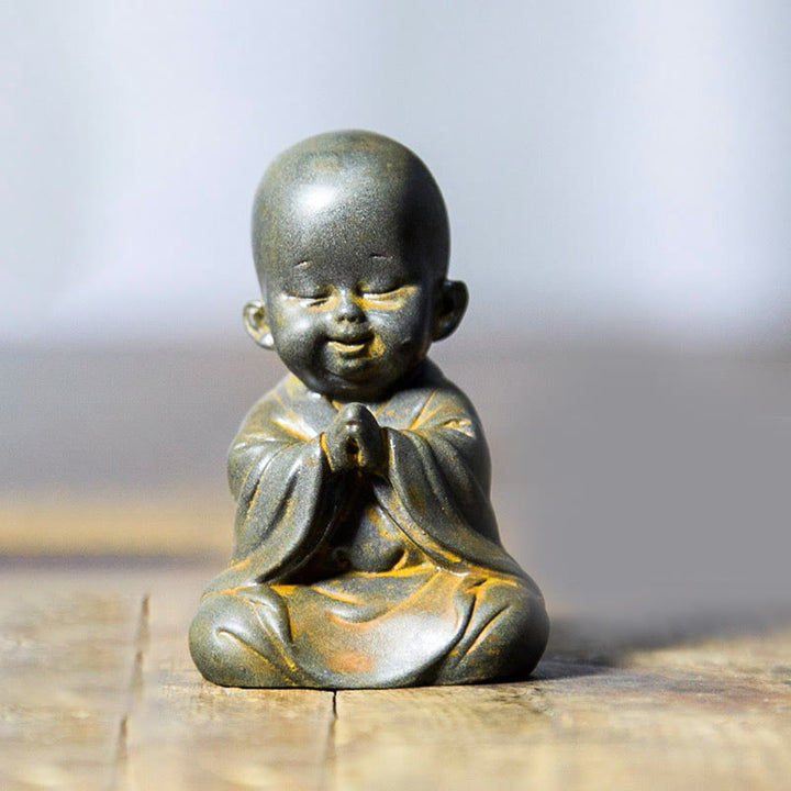 Estatua de resina fundida oxidada con polvo de hierro de un pequeño monje meditando Buddha Stones para decoración de escritorio