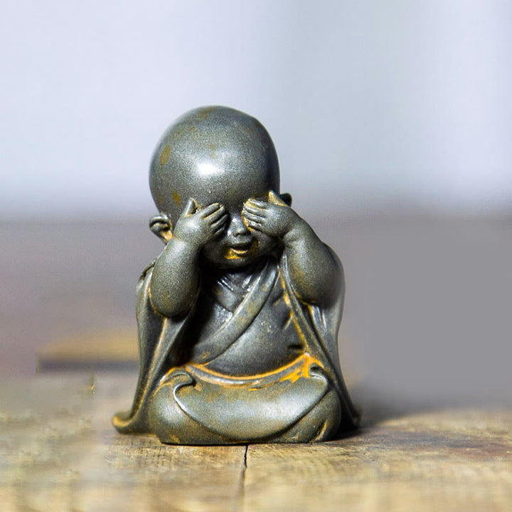 Estatua de resina fundida oxidada con polvo de hierro de un pequeño monje meditando Buddha Stones para decoración de escritorio