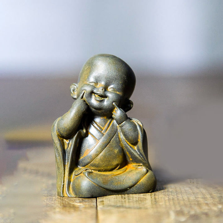 Estatua de resina fundida oxidada con polvo de hierro de un pequeño monje meditando Buddha Stones para decoración de escritorio