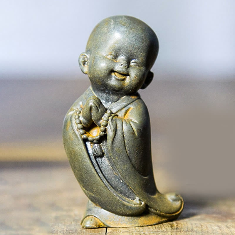 Estatua de resina fundida oxidada con polvo de hierro de un pequeño monje meditando Buddha Stones para decoración de escritorio