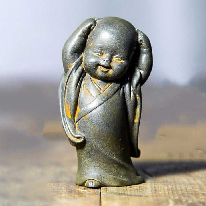 Estatua de resina fundida oxidada con polvo de hierro de un pequeño monje meditando Buddha Stones para decoración de escritorio