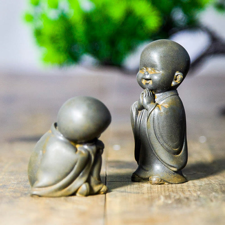 Estatua de resina fundida oxidada con polvo de hierro de un pequeño monje meditando Buddha Stones para decoración de escritorio