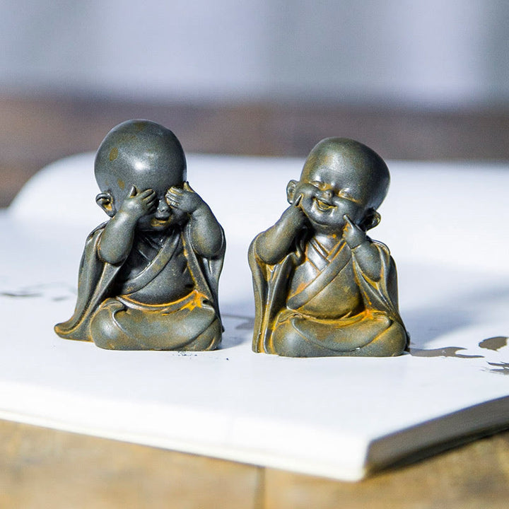 Estatua de resina fundida oxidada con polvo de hierro de un pequeño monje meditando Buddha Stones para decoración de escritorio