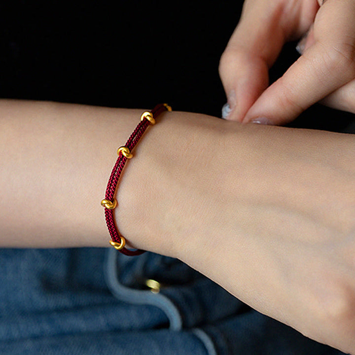 Pulsera trenzada de cuerda con diseño de nudo de los deseos hecha a mano con Buddha Stones en oro 999