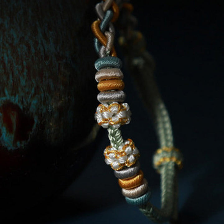 Pulsera de cuatro hilos con Buddha Stones y flor de durazno