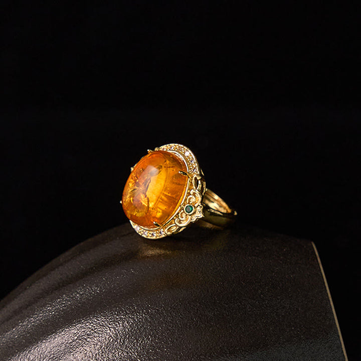 Anillo de enfoque con diseño de huevo de paloma y flor de ámbar con Buddha Stones