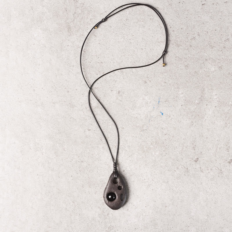 Collar con colgante de obsidiana hueca con incrustaciones de madera de ébano y Buddha Stones que expresan la paz y la calma