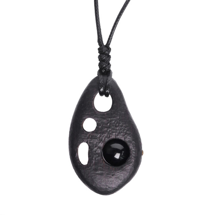 Collar con colgante de obsidiana hueca con incrustaciones de madera de ébano y Buddha Stones que expresan la paz y la calma