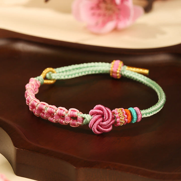 Pulsera trenzada con nudo de flor de durazno verde y rosa hecha a mano con Buddha Stones