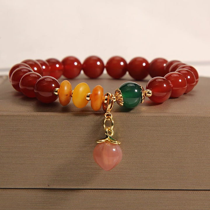 Pulsera de autoaceptación con dijes de melocotón, ámbar y ágata roja de Buddha Stones