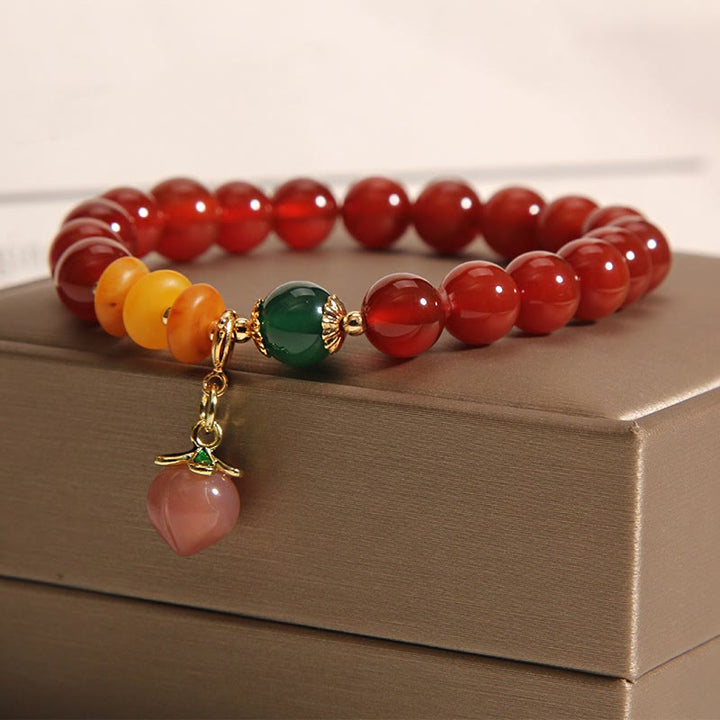 Pulsera de autoaceptación con dijes de melocotón, ámbar y ágata roja de Buddha Stones