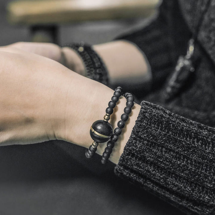 Pulsera protectora de doble envoltura con cuentas de ébano y ónix negro con superficie cortada esmerilada y Buddha Stones
