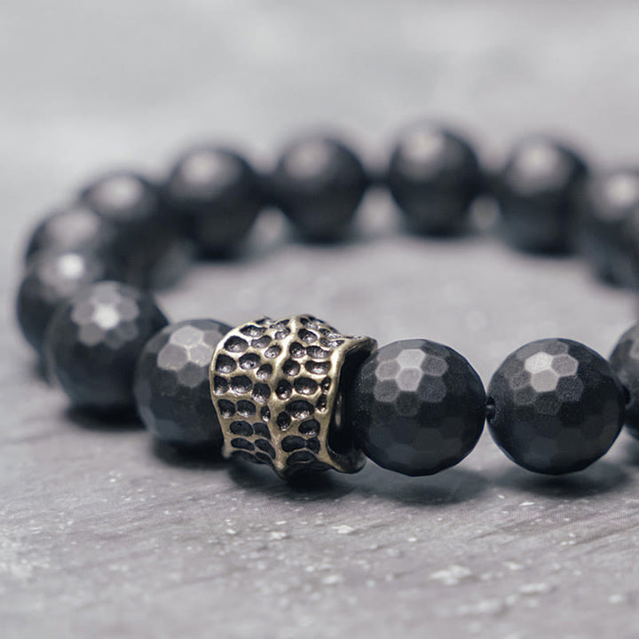 Pulsera protectora de latón y cobre con ónix negro mate y Buddha Stones