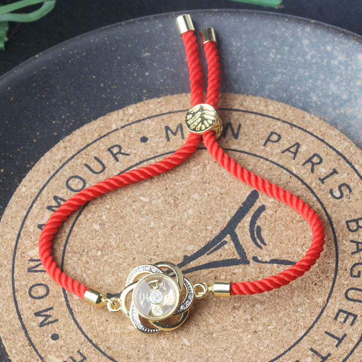 Pulsera trenzada con protección de Qi y Feng Sheng Shui con molino de viento de cobre y latón con hilo rojo ciruela giratorio y Buddha Stones