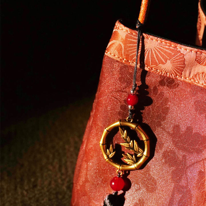 Buddha Stones Bolso de mano de seda Xiangyunsha con borlas bordadas con ramas de bambú y flores de ciruelo