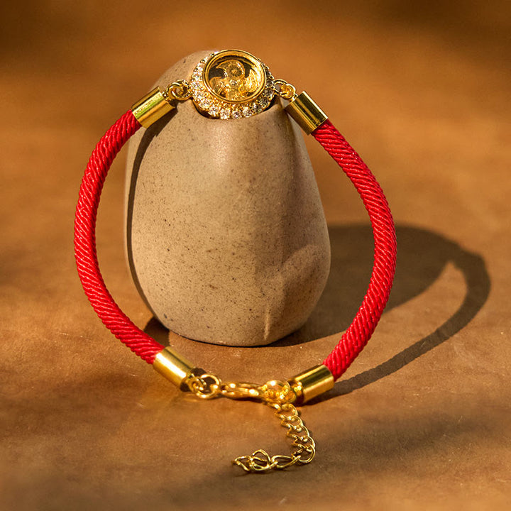 Pulsera trenzada con protección de Qi Feng Sheng Shui con molino de viento giratorio de cobre y latón con hilo rojo y Buddha Stones