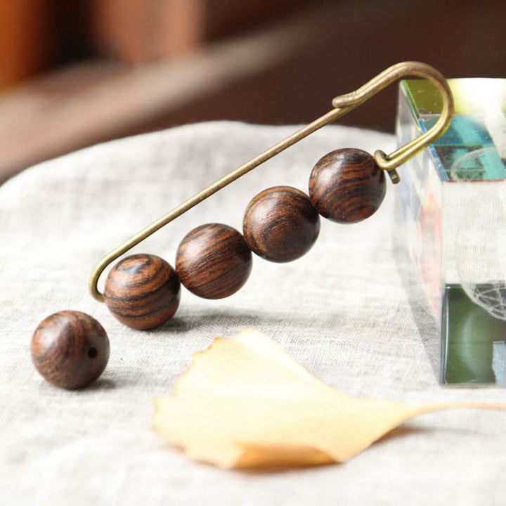 Broche curativo con cuentas de peltogyne, agathis alba, sándalo y madera de ébano de Buddha Stones
