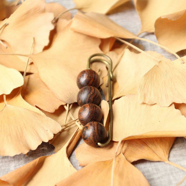 Broche curativo con cuentas de peltogyne, agathis alba, sándalo y madera de ébano de Buddha Stones