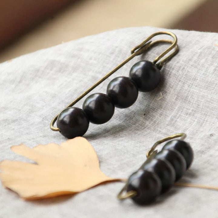 Broche curativo con cuentas de peltogyne, agathis alba, sándalo y madera de ébano de Buddha Stones