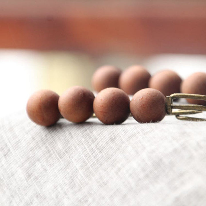 Broche curativo con cuentas de peltogyne, agathis alba, sándalo y madera de ébano de Buddha Stones