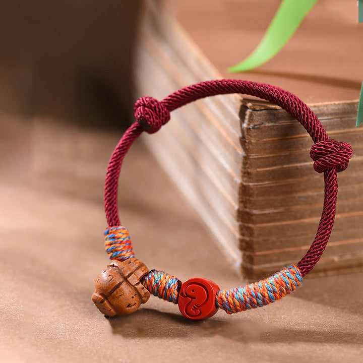 Pulsera de la suerte hecha a mano con Buddha Stones y cinabrio de hueso de melocotón con hilo rojo del zodíaco chino