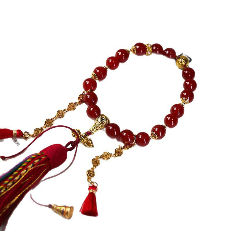 Mala de muñeca con 18 cuentas de Buddha Stones , monedas de cobre, borla tibetana, ágata roja, calmante