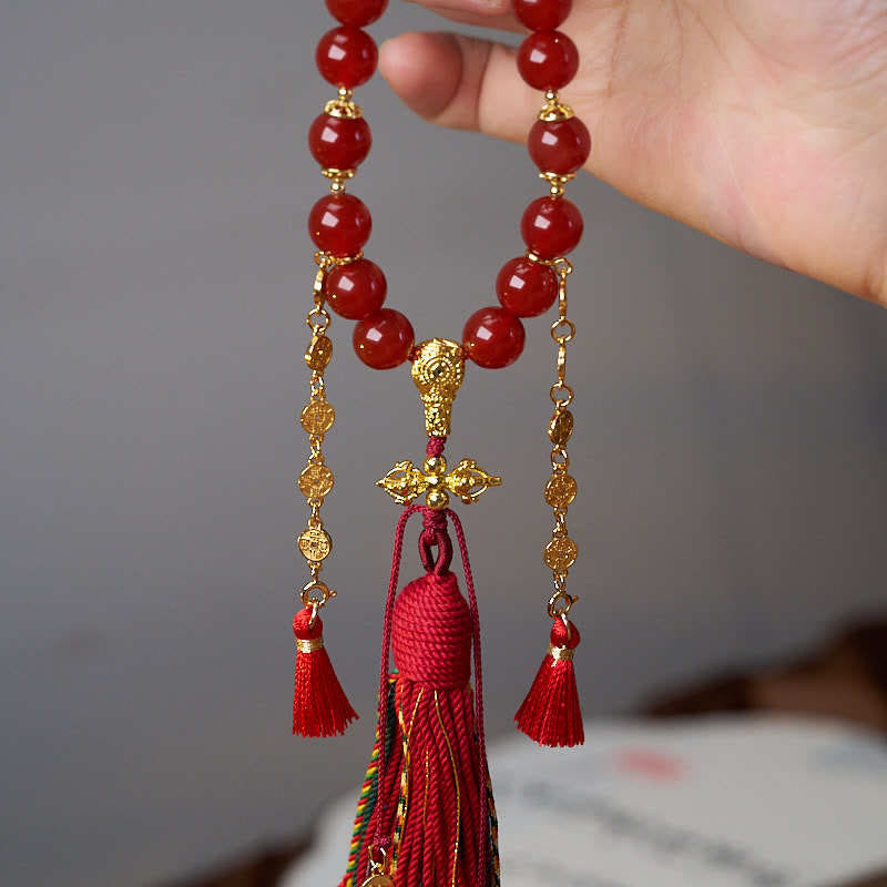 Mala de muñeca con 18 cuentas de Buddha Stones , monedas de cobre, borla tibetana, ágata roja, calmante