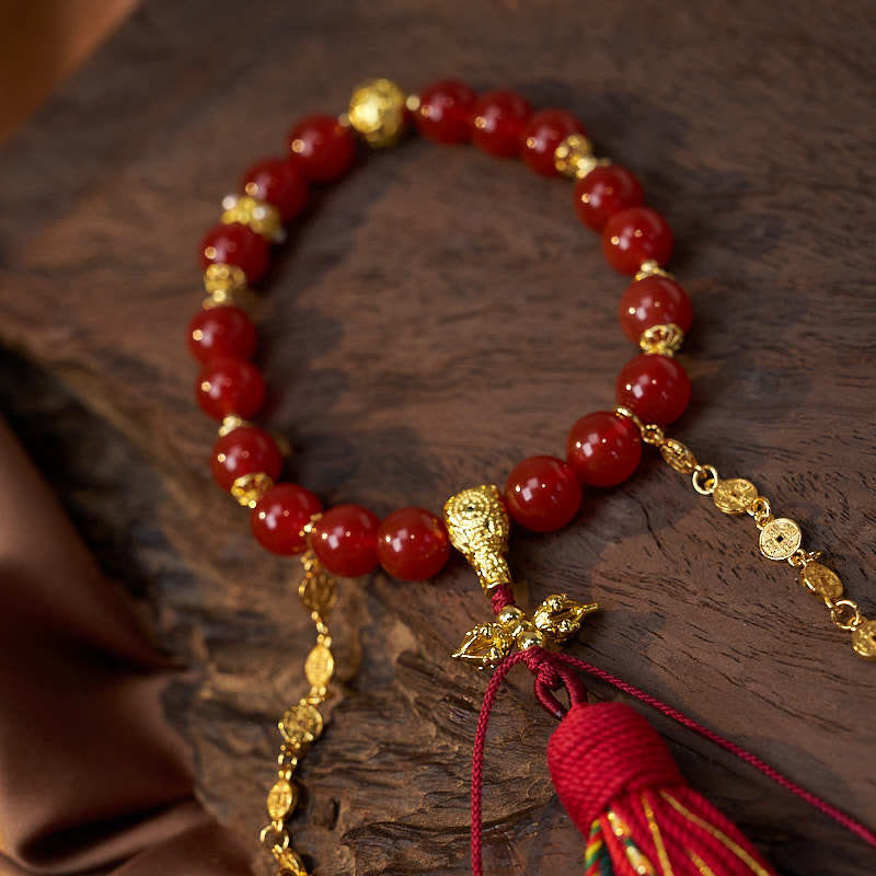 Mala de muñeca con 18 cuentas de Buddha Stones , monedas de cobre, borla tibetana, ágata roja, calmante