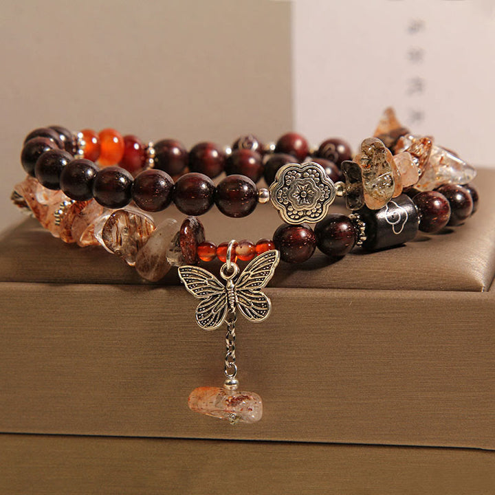Pulsera con dije de mariposa de la riqueza de sándalo rojo con hojas pequeñas de cuarzo rutilado natural de Buddha Stones