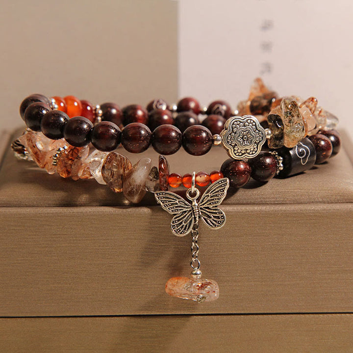 Pulsera con dije de mariposa de la riqueza de sándalo rojo con hojas pequeñas de cuarzo rutilado natural de Buddha Stones