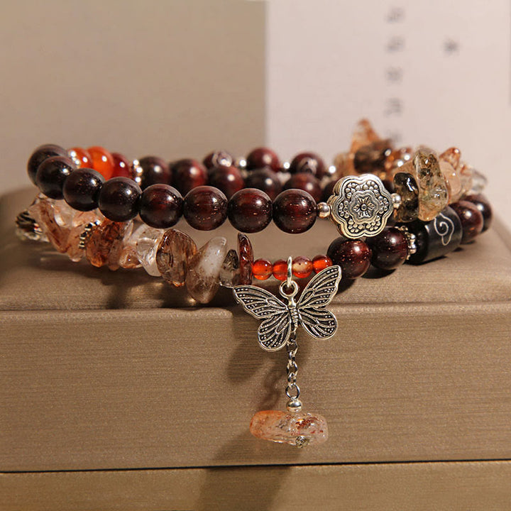 Pulsera con dije de mariposa de la riqueza de sándalo rojo con hojas pequeñas de cuarzo rutilado natural de Buddha Stones