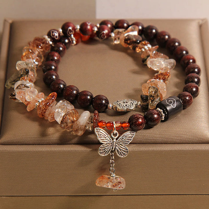 Pulsera con dije de mariposa de la riqueza de sándalo rojo con hojas pequeñas de cuarzo rutilado natural de Buddha Stones