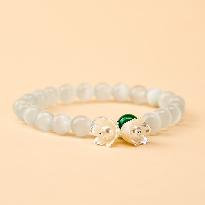 Buddha Stones Pulsera con cuentas redondas blancas de ojo de gato de 8 mm y flores de lirio del valle. - image 1