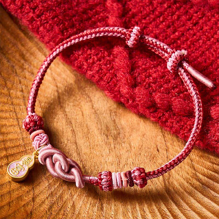 Buddha Stones Pulsera de hilo rosa con la frase "Hazte rico rápidamente" tejida a mano con la frase "Refuerza tu calabaza" - image 1