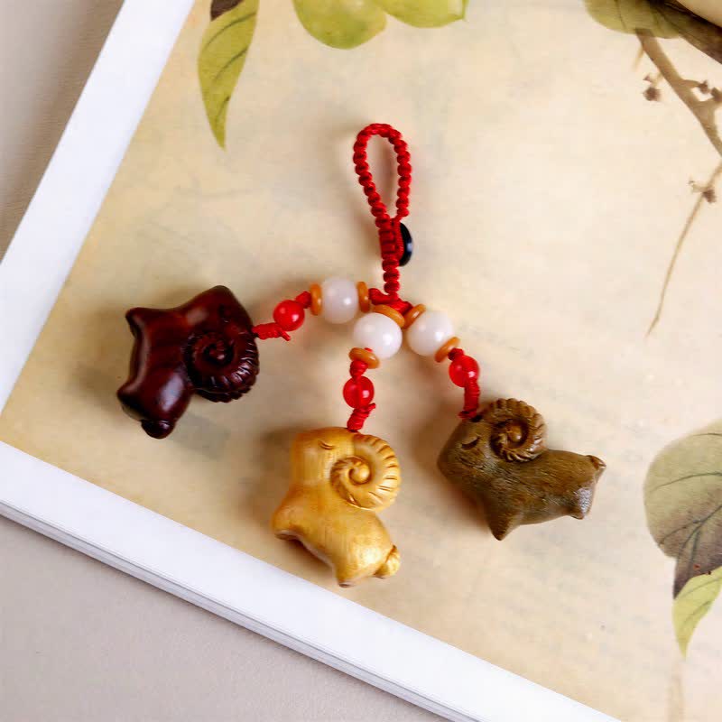 Buddha Stones Llaveros de prosperidad con tres cabras, tallados a mano en madera de sándalo y ébano. - image 1