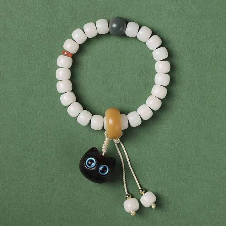 Pulsera de armonía de paz con dije de gato encantador de madera negra africana con semillas de Bodhi naturales de Buddha Stones - Semilla Bodhi de gato de ojos azules - image 6