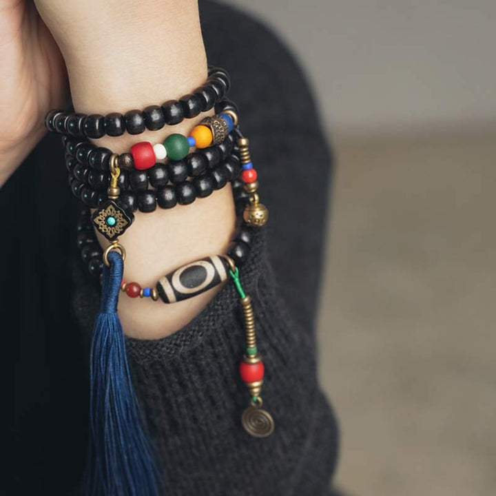 Buddha Stones 108 cuentas Mala madera de ébano cuentas Dzi cobre equilibrio borla pulsera