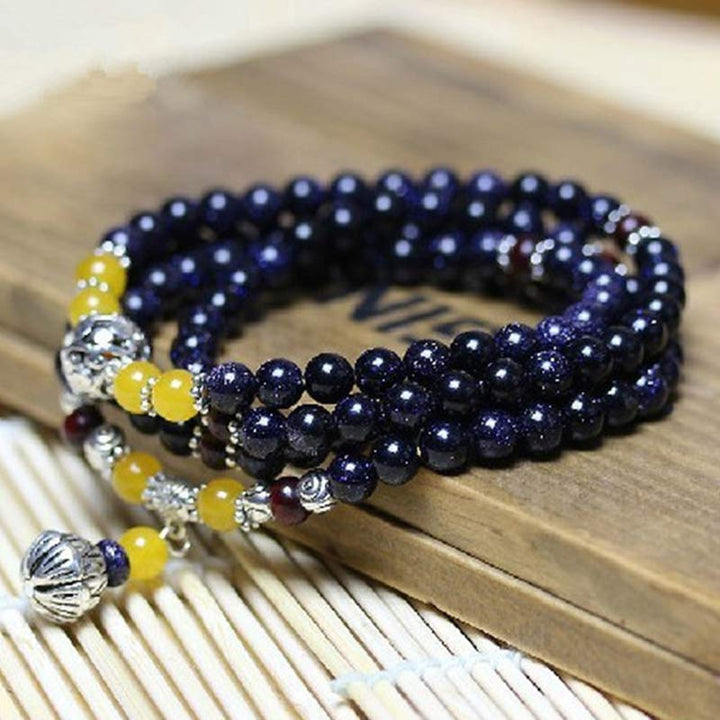 Pulsera con dijes de riqueza de arenisca azul con Buddha Stones Mala