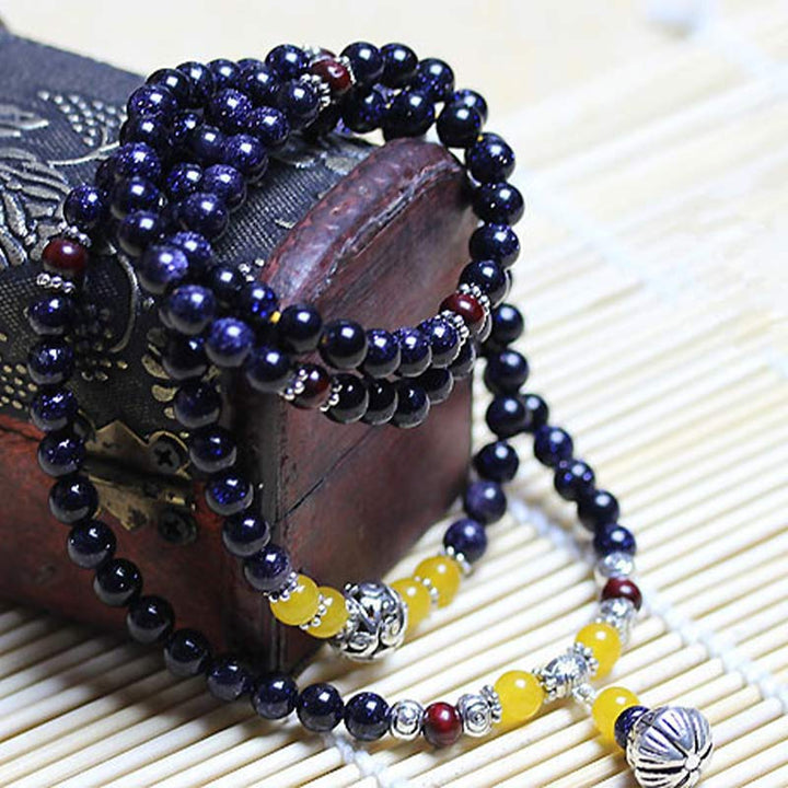 Pulsera con dijes de riqueza de arenisca azul con Buddha Stones Mala