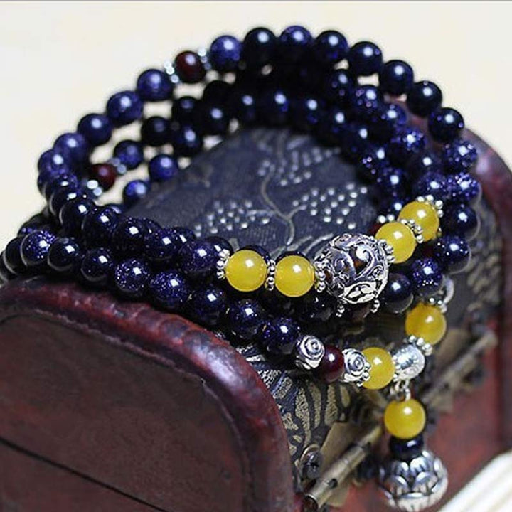 Pulsera con dijes de riqueza de arenisca azul con Buddha Stones Mala