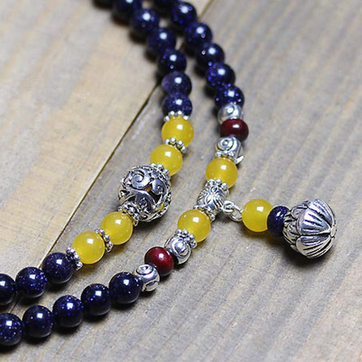 Pulsera con dijes de riqueza de arenisca azul con Buddha Stones Mala